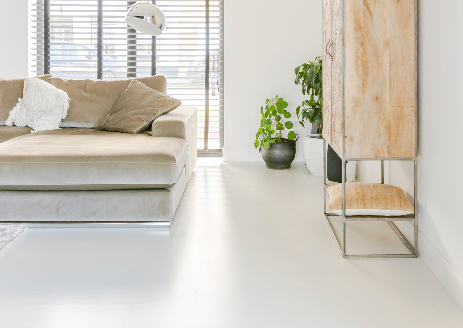 Naadloze gietvloer in moderne woonkamer met warme uitstraling en eigentijdse inrichting.